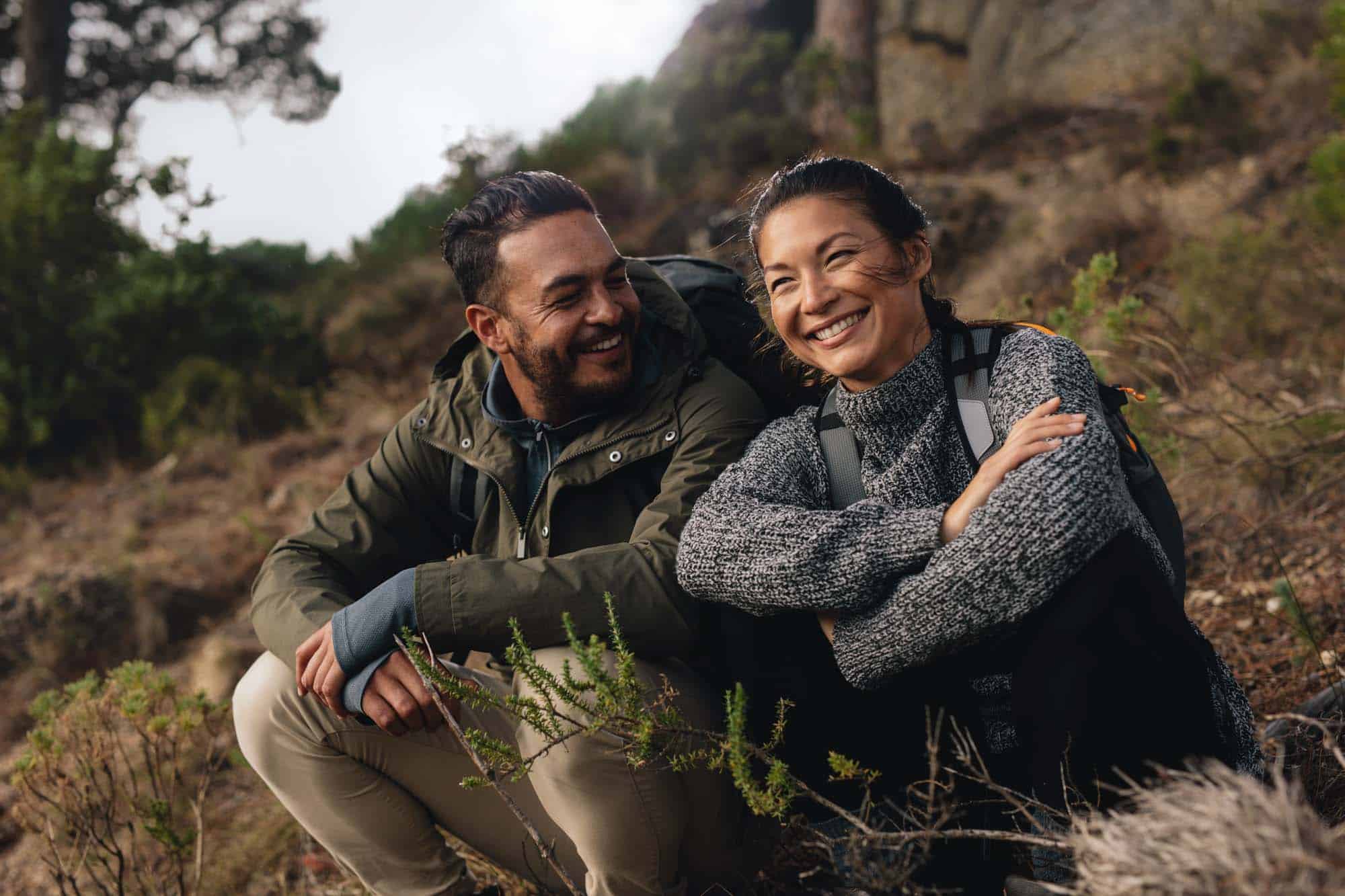 Hiking couple sitting on mountain trail